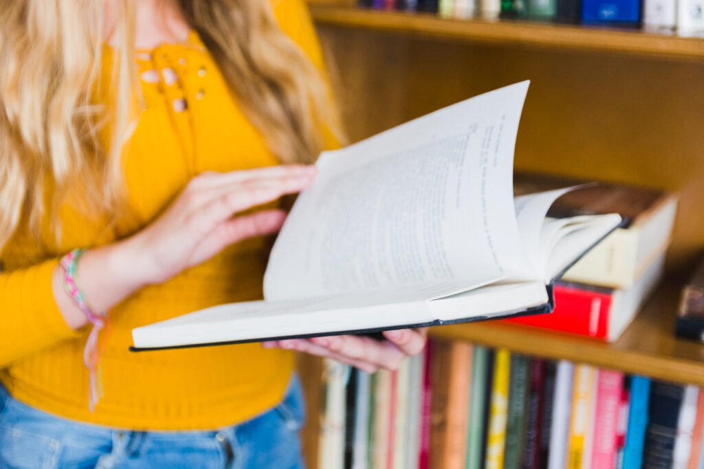 Teenager turning over book pages